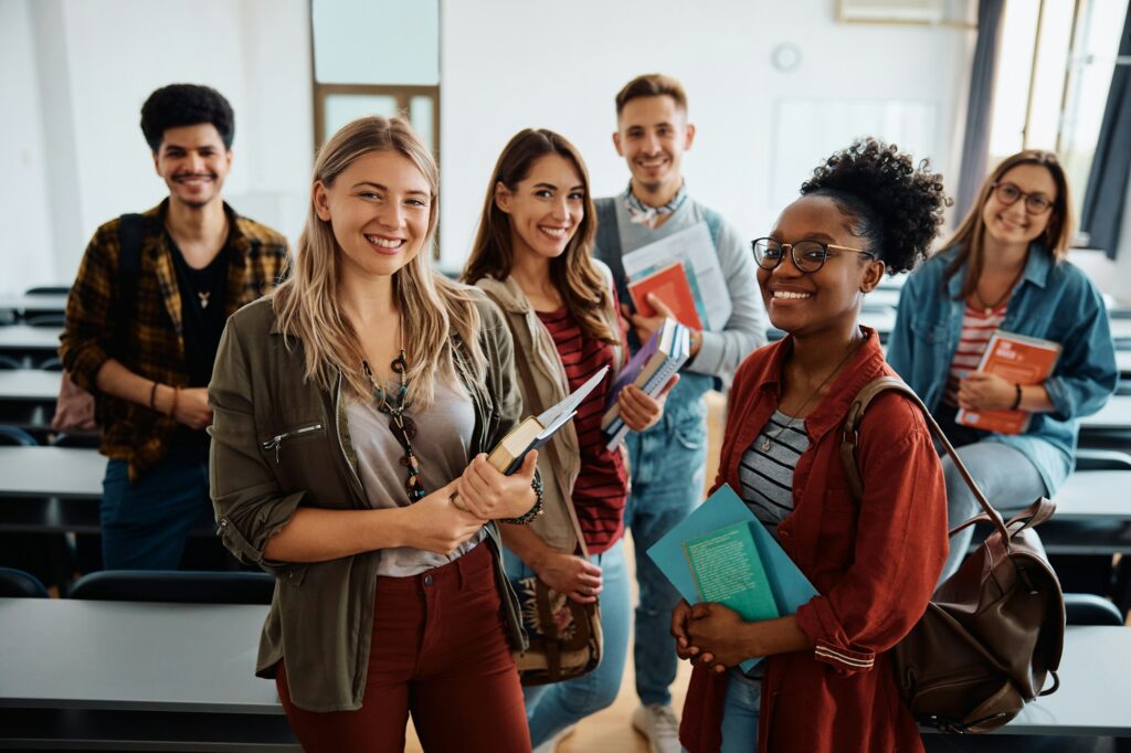 Multi-ethnic group of university students in lecture hall looking at camera.